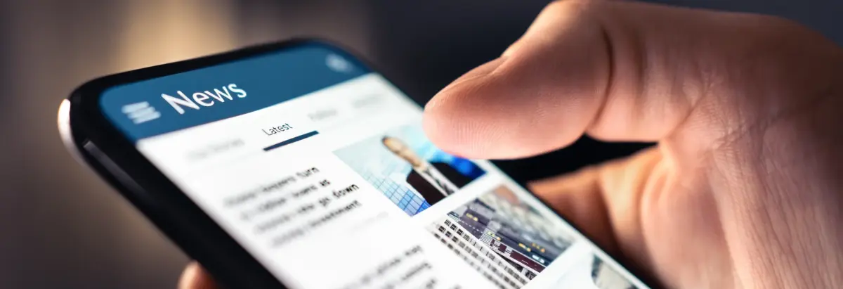 User reading news articles on mobile to convert website to RSS feed for content aggregation