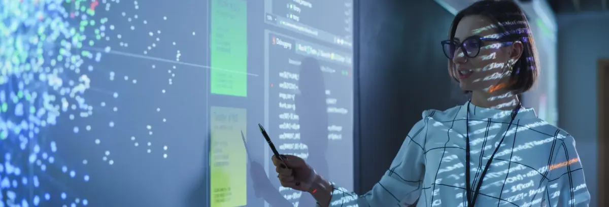 Why use big data - professional woman presenting analytics visualizations in modern technology data center